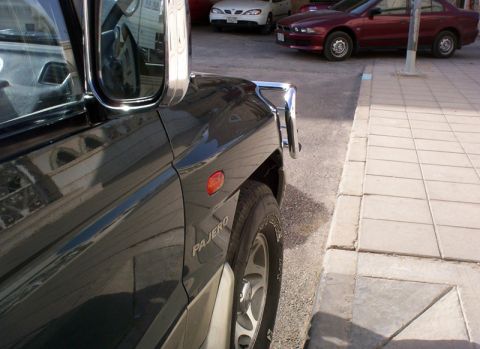 2000 Mitsubishi Montero - Front corner of a dark 2000 Mitsubishi Montero, parked curbside with other vehicles visible.