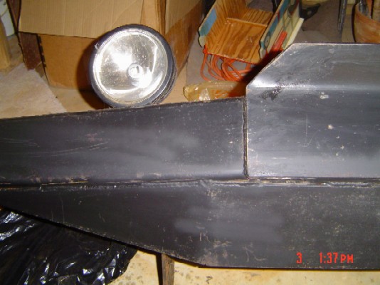 Black bumper section with a round headlight mounted above it