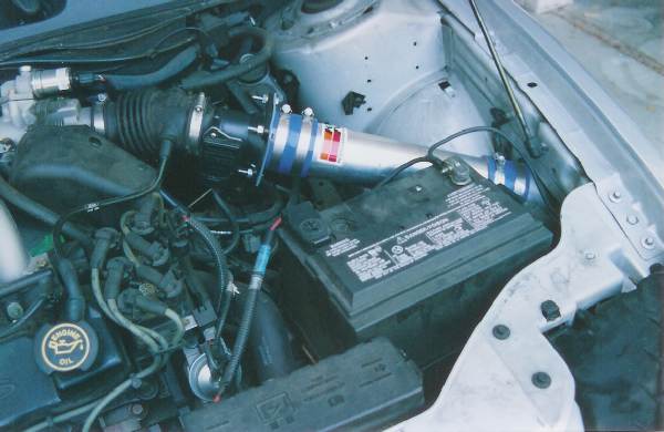 Engine bay showing aftermarket cold air intake and battery