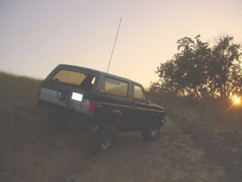 1988 Ford Bronco - This 1988 Ford Bronco is captured on a grassy incline during a sunset, its profile.