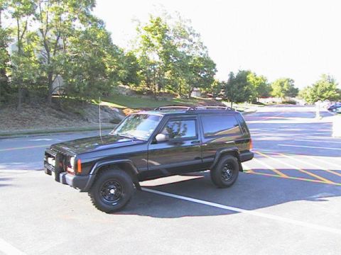 2000 Jeep Liberty - This black Jeep Cherokee XJ is parked in a lot with yellow and white lines.