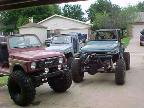 1978 Ford Bronco - Three Suzuki Samurai vehicles are parked in a driveway.