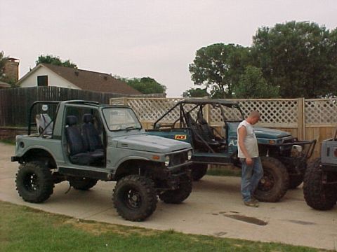 1978 Ford Bronco - Modified off-road SUVs parked in a driveway with a man standing nearby.