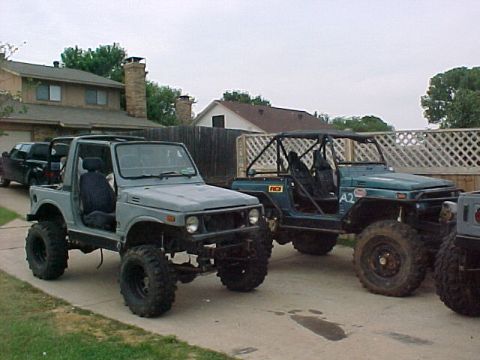 1978 Ford Bronco - Two off-road modified Suzuki Samurai vehicles are parked in a driveway next to a house.