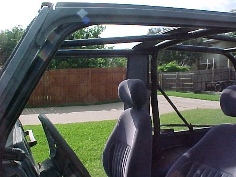 1978 Ford Bronco - The interior of a vehicle is shown, a roll cage and seats, with a Supermotors.net logo in the lower right corner.