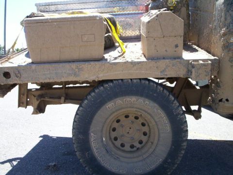 1978 Ford Bronco - Truck bed loaded with toolboxes and a spare tire, covered in dirt and mud.