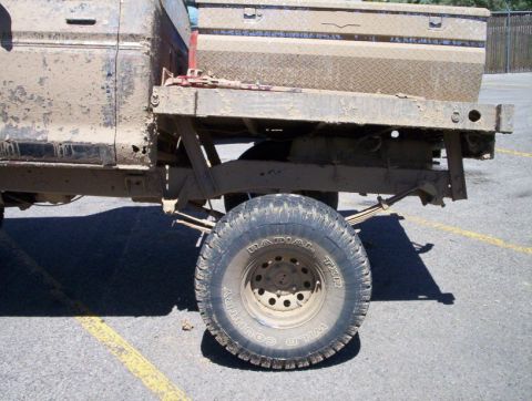 1978 Ford Bronco - This is a side view of a dirty pickup truck, focusing on the rear wheel and flatbed.