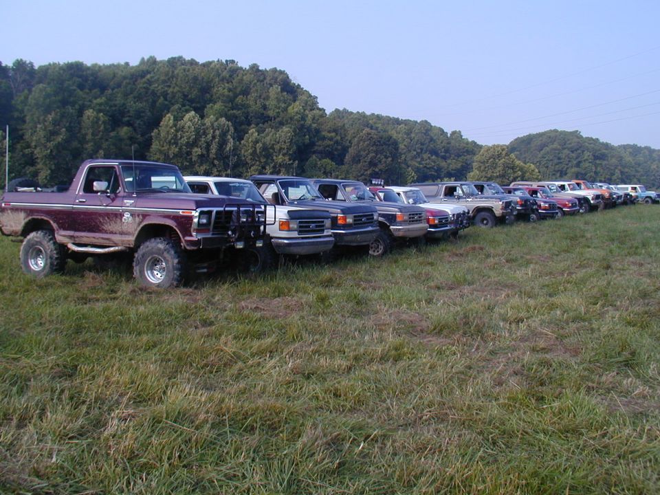 Maroon SUV with off-road tires parked in a line of vehicles