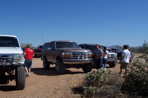 1992 Ford Bronco - Several SUVs are parked in a desert landscape under a clear blue sky.