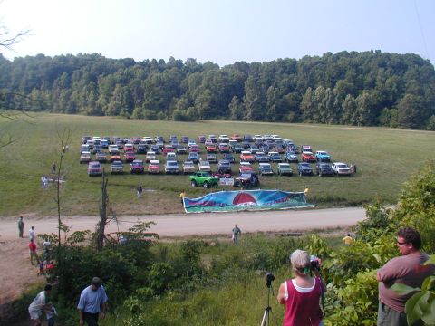 1988 Ford Bronco - A large group of SUVs and trucks are gathered in an open field.