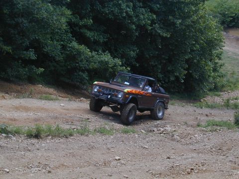 1988 Ford Bronco - This classic Ford Bronco navigates an off-road trail with its distinctive flame graphics.