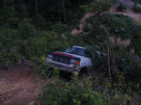 1988 Ford Bronco - White 1988 Ford Bronco navigating a wooded off-road trail.