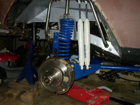 1995 Ford Bronco - The vehicle's suspension and brake system are visible, supported by jack stands and a hydraulic jack.