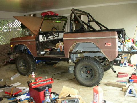 1995 Ford Bronco - Ford Bronco in a garage with the hood and driver's door open, showing interior and engine bay.