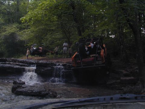 1988 Ford Bronco - Off-road vehicles navigate a rocky terrain with a waterfall.