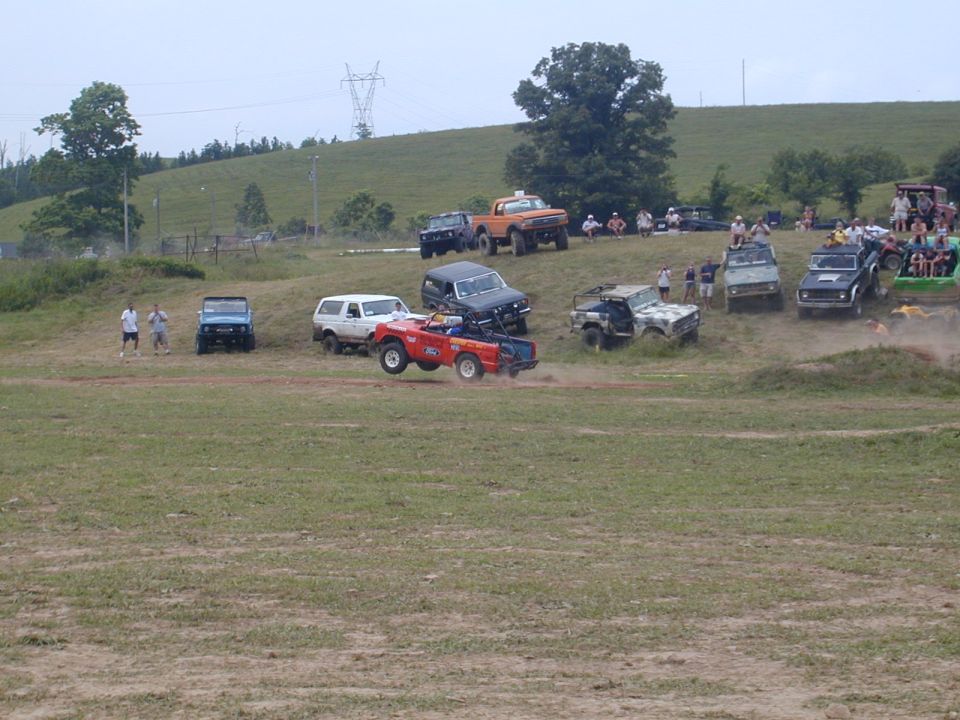 Red off-road vehicle mid-air jump, 1988 Ford Bronco