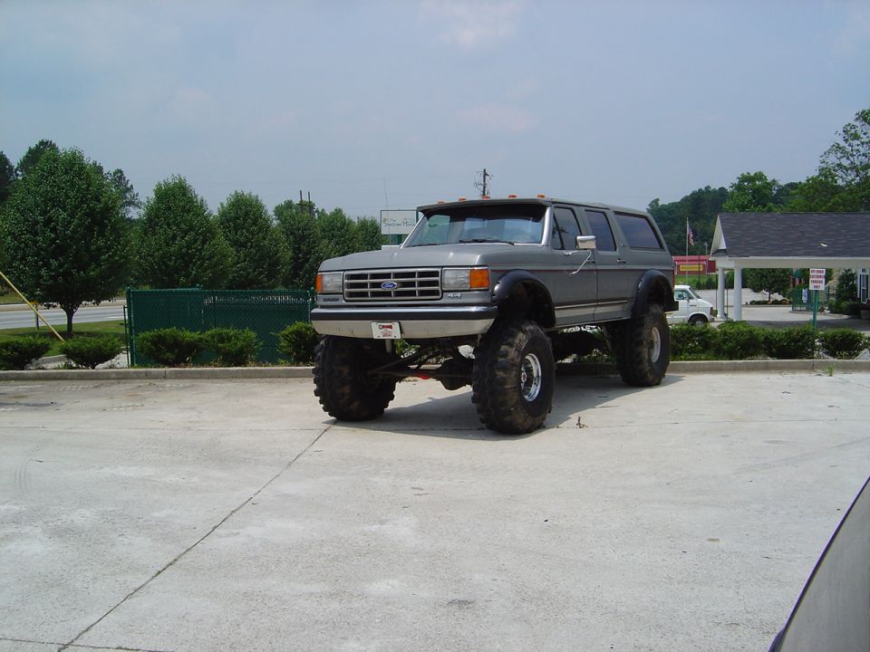 Gray lifted Ford Bronco with large tires parked outside