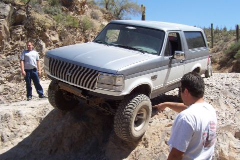 1992 Ford Bronco - This 1992 Ford Bronco is shown tackling a challenging off-road course in a desert environment.