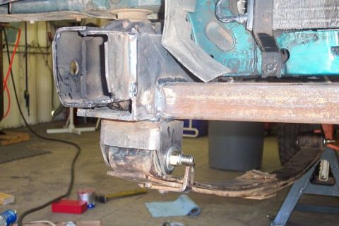 1990 Ford Bronco - The underside of a vehicle shows suspension components and frame structure, possibly undergoing maintenance or modification.