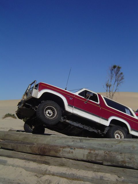 1982 Ford Bronco - This 1982 Ford Bronco is navigating an obstacle course made of logs on a beach.