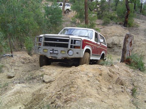 1982 Ford Bronco - This SUV navigates a challenging off-road terrain with steep inclines and loose dirt.