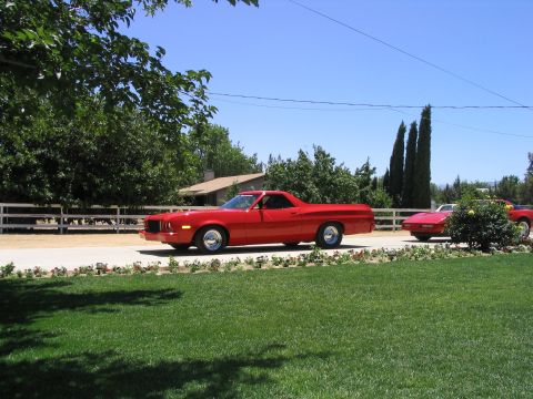 1974 Ford Ranchero - A red 1974 Ford Ranchero is seen driving on a road with another car behind it.