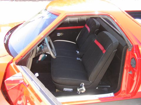 1974 Ford Ranchero - The interior of a 1974 Ford Ranchero shows black seats with red accents and a grey steering wheel.