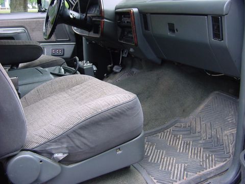 1989 Ford Bronco - The interior of a 1989 Ford Bronco is visible, plaid seats and a dark dashboard.