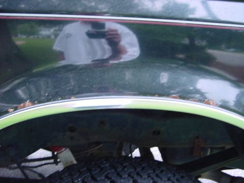 1989 Ford Bronco - Close-up of a vehicle's rear wheel well and fender area, showing tire and chrome trim.