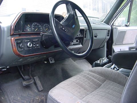 1989 Ford Bronco - The interior of this truck shows a dashboard with gauges, a steering wheel, and a radio, along with the passenger seat.