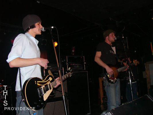 Band playing guitars and singing on stage
