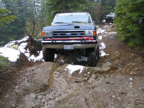 1991 Ford Bronco - A 1991 Ford Bronco tackles a challenging off-road course with another vehicle visible in the background.