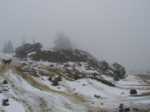 1991 Ford Bronco - Two SUVs navigate a treacherous snowy and rocky terrain, with one appearing to be stuck.