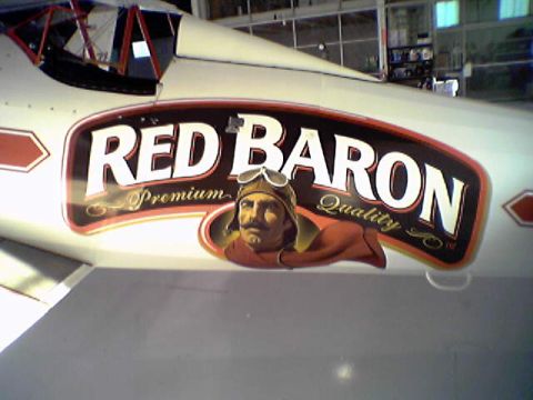 1998 Ford Crown Victoria - The side of an aircraft displays a prominent 'Red Baron' logo with a stylized aviator portrait.