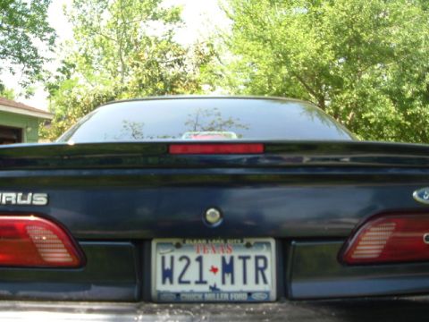 1993 Ford Taurus - The rear of a dark blue Ford Taurus is shown, a spoiler and a Texas license plate.