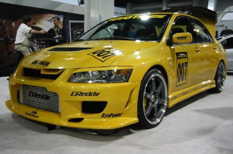 1993 Ford Taurus - This modified yellow sedan displays numerous racing decals and an aggressive body kit.