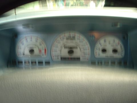 1993 Ford Taurus - The blurry interior shot shows the instrument cluster of a vehicle, with the speedometer and tachometer prominently displayed.