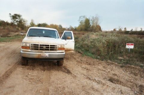 1993 Ford Bronco - This white Ford F-Series truck, likely a 1992 model, is seen with its driver's door ajar on a muddy track.