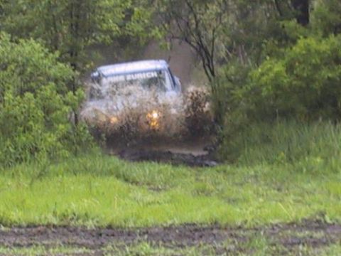 1993 Ford Bronco - Vehicle splashes through mud and water on an off-road trail.
