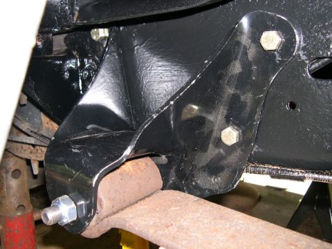 1994 Ford Bronco - A close-up view shows a black painted metal bracket attached to a rusty suspension component.