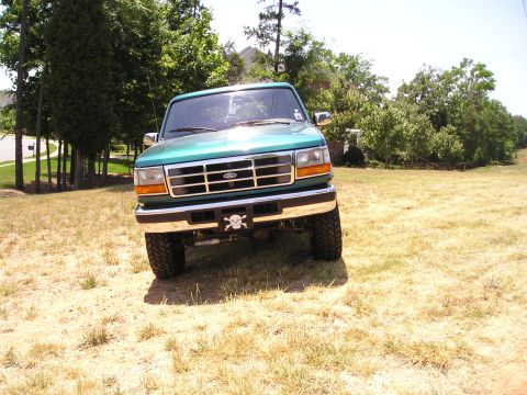 1996 Ford Bronco - Green 1996 Ford Bronco with a skull license plate frame sits on dry grass.