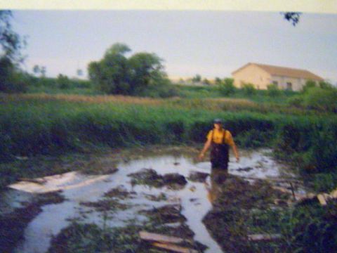 1993 Ford Bronco - A person walks through a muddy field with a building in the background.