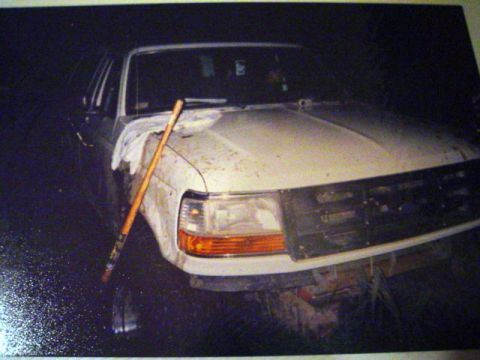 1993 Ford Bronco - A dirty white Ford truck is shown from the front, with a broom resting on its hood.