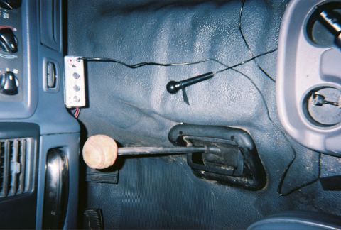 1993 Ford Bronco - The interior of a vehicle is shown, focusing on the gear shifter and surrounding console area with various wires and controls.