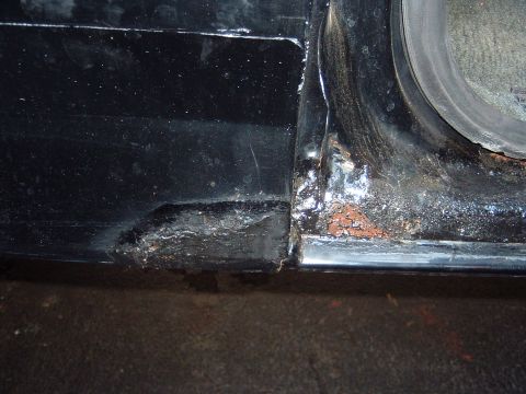 1993 Ford Bronco - This photo shows significant rust damage on the door sill and rocker panel of a vehicle.