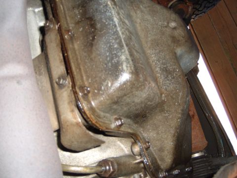 1993 Ford Bronco - Underside view of a vehicle's transmission pan, showing some oil residue around the gasket.