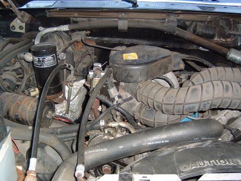 1993 Ford Bronco - Close-up view of the engine bay, showing various hoses, the air filter housing, and other engine components.