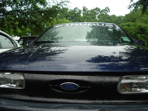 1993 Ford Taurus - Front view of a dark blue 1993 Ford Taurus, a banner across the top of the windshield.