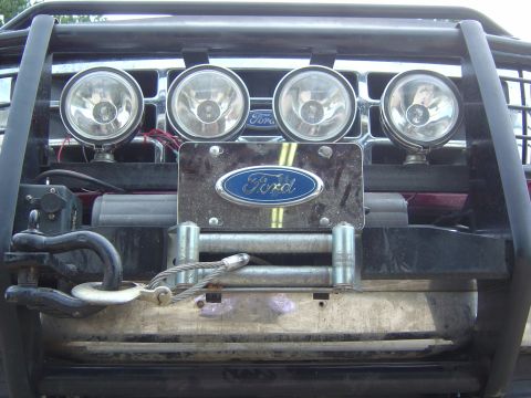 1993 Ford Bronco - Front view of a 1993 Ford Bronco, a winch, auxiliary lights, and the iconic Ford emblem on the grille.