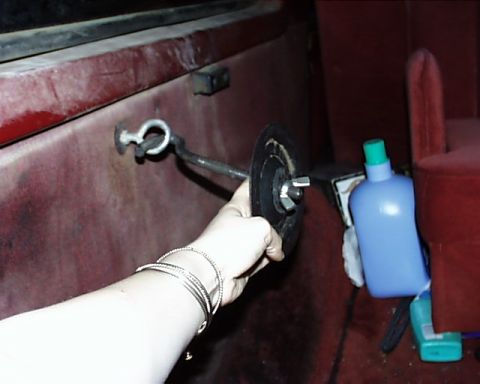 1988 Ford C-350 (Centurion Conversions) - Interior view of a vehicle with a hand holding a part near a hook.